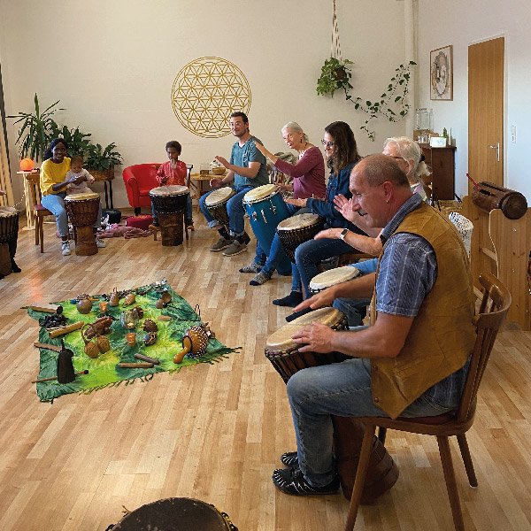 Eine Gruppe Workshopteilnehmern beim Trommeln auf der Djembe